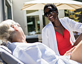 Happy senior women friends sunbathing on spa patio