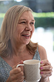 Happy senior woman drinking tea