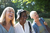 Happy senior women friends laughing in summer garden