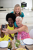 Senior women friends in dresses taking selfie