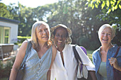 Portrait playful senior women friends in summer garden