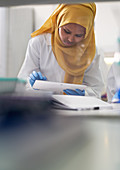 Scientist in hijab using digital tablet