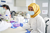Scientist in hijab in face mask working
