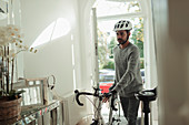 Man at front door with bicycle and cycling helmet