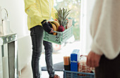 Delivery man with grocery crates at front door