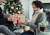 Happy couple opening Christmas gifts in living room