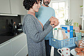 Couple unpacking groceries at kitchen counter