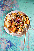 Roasted cauliflower salad with red onion, raisins, pine nuts, chili and herbs