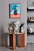 Side table with decorative objects, framed picture above it
