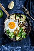 Chilaquiles - blaue Maistortillas, schwarze Bohnen, Avocado. Spiegelei, Cheddar, Jalapenos, Koriandergrün und Limette