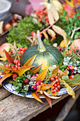 Runde Zucchini im bunten Herbstkranz aus Herbstlaub und Beeren