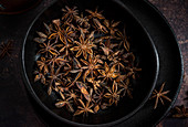 Star anise pods in a black plate