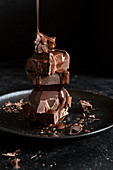 Schokoladensauce tropft auf Stapel von Schokoladenstücken