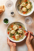 Female eating chicken and dumpling soup