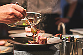 Schweinefilet mit Sauce beträufeln in französischem Restaurant