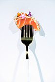 Salmon sashimi with caviar and herbs on fork