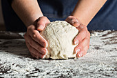 Kneading bread dough on table with flour