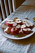 Äpfel, ganz und halbiert auf Teller