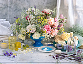 Wellness still life: bouquet of flowers, scented oils, lavender soap, bath salts, natural sponge