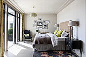 Doppelbett mit hohem Kopfteil und schwarz-weiße Fotografie im Schlafzimmer mit Balkon