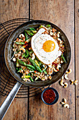 Fried rice with green asparagus, fried egg and cashew nuts