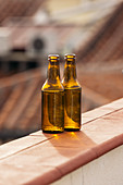 Two beer bottles on balcony wall