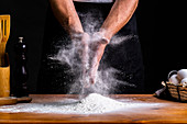 Clapping hands in flour while making bread dough
