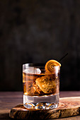 Old Fashioned Cocktail mit Orangenschale und Eiswürfeln