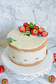 Yoghurt cake with tonka bean, strawberries and flower decoration