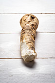 Horseradish root on white wooden background