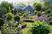 Hanggarten mit Pavillon und Beet mit Rosenstämmchen, eingefasst mit Buchshecke
