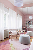 Wardrobe with mirrored doors in girl's bedroom with pink wallpaper