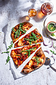 Pizza mit Salami, Basilikumöl und frischem Rucola