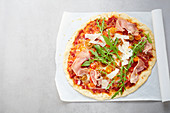 A pizza with Parma ham, rocket and Parmesan