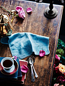 Kaffeegeschirr und silberne Löffel auf altem Holztisch