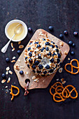 Goat's cheese ball with blueberries, honey and pretzels