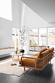 Braunes Sofa mit Samtpolster und Coffeetable in hellem, hohem Wohnraum