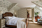 Antikes Bett in floral tapeziertem Schlafzimmer