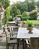 Table and chairs on terrace with climbing rose