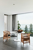 Zwei Korbstühle am Designertisch vorm Balkon mit Panoramablick