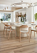 Large, round table and pale wooden chairs in modern dining room