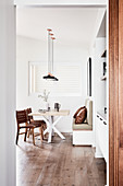 View into modern dining room in natural shades with wooden floor