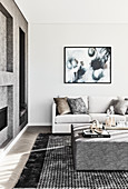 Elegantes Wohnzimmer in Weiß und Grau mit gepolstertem Couchtisch