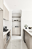 Marble floor tiles in bright, modern kitchen with grey cabinets