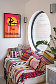 Surfing poster above window seat in large porthole window