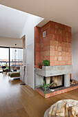 Kamin aus Terrakottafliesen und Beton in offenem Wohnraum