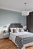 Wand mit Tapete und Kassettenverkleidung im eleganten Schlafzimmer