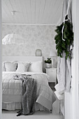 Doppelbett mit Kissen im Schlafzimmer mit romantischer Blumentapete