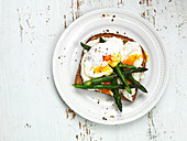 Poached eggs with green asparagus on toast