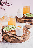 Frühstück mit Avocadobrot, gekochtem Ei und Saft